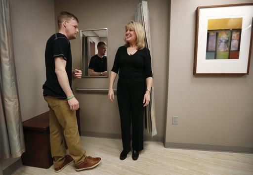AP Exclusive: Twin tragedies give survivor a new face